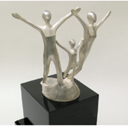 The NIIC Spirit of Life award trophy depicts three silver toned persons with their arms wide open, leaning forward with joy.