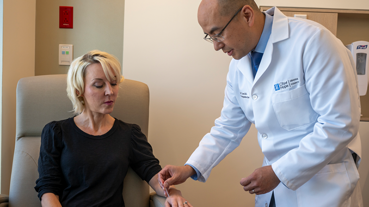 Richard T. Lee, M.D., Cherng Family Director’s Chair for the Center for Integrative Oncology, places a needle for acupuncture treatment onto a patient’s arm.