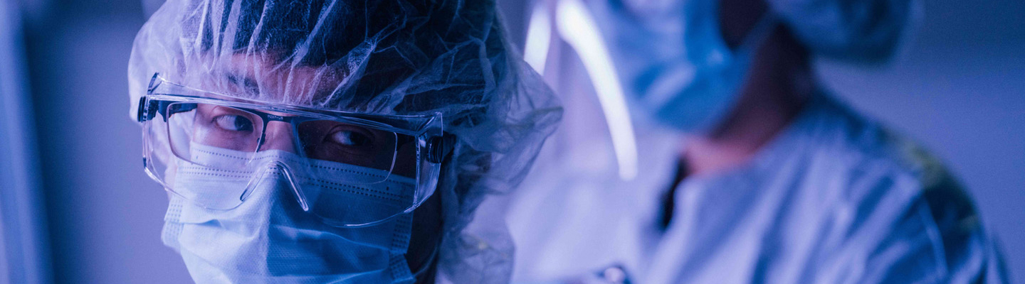 Scientists in a laboratory wearing protective work wear.