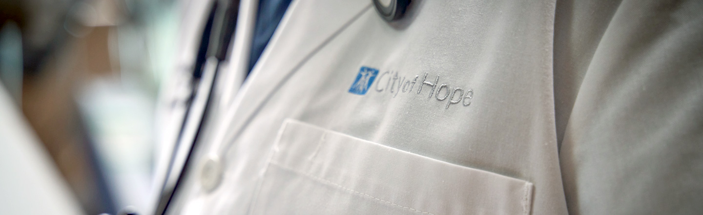 Close-up of City of Hope logo embroidered on a white doctor's coat.