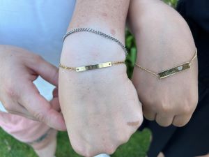 Hannah Bradley and Camila Quino's wear matching gold bracelets
