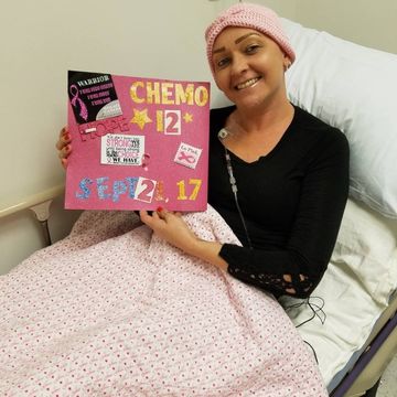 Jennifer Rancik holding 12th round of chemotherapy sign.