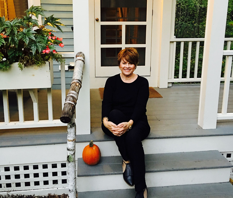 Photo of LeeAnn sitting on the stairs of a porch.
