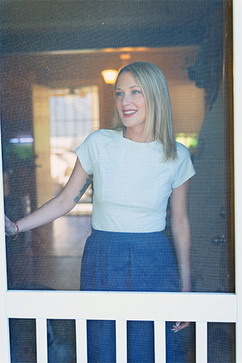 Nicole Schulz Cancer Survivor Standing Behind Screen Door