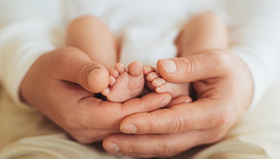 Hands around a child's feet