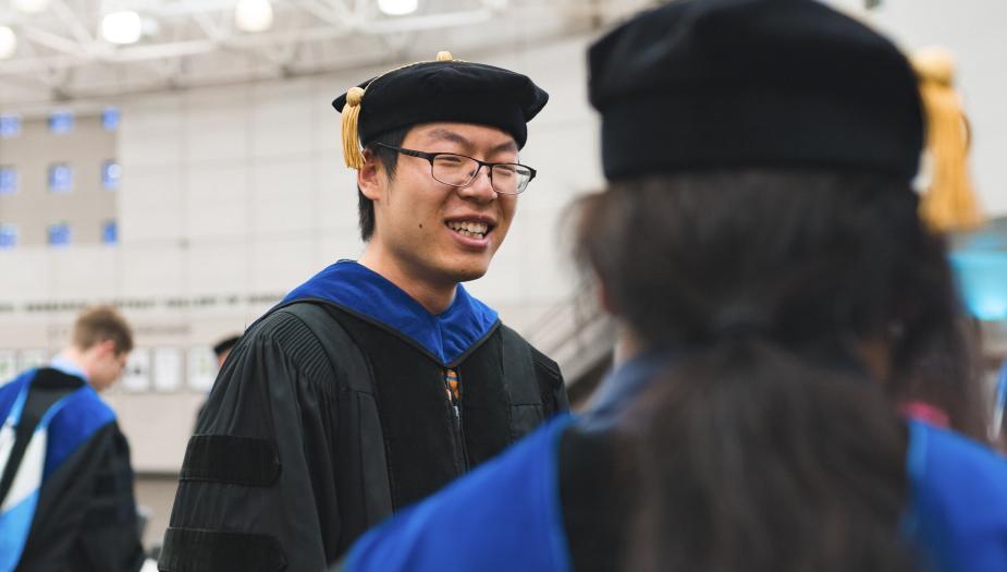 Two people at a graduation ceremony