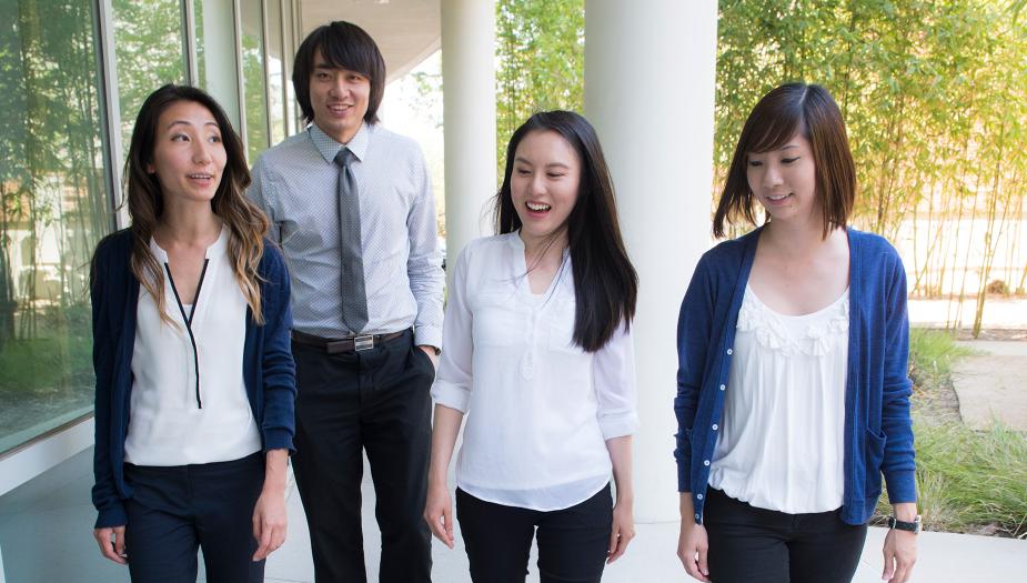 Four students walking towards the camera