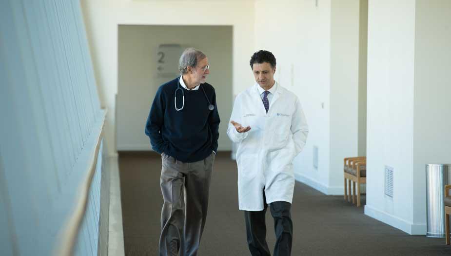 Dr. Forman and Dr. Badie walking together and having a conversation