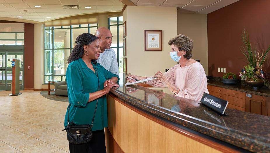 Two visitors receiving help at Guest Services desk
