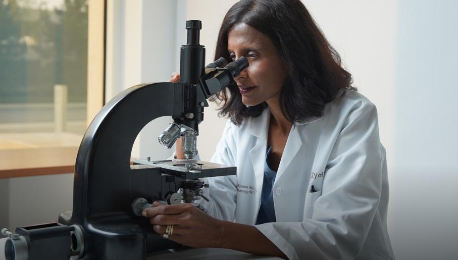 Doctor Amrita Krishnan looking into a microscope