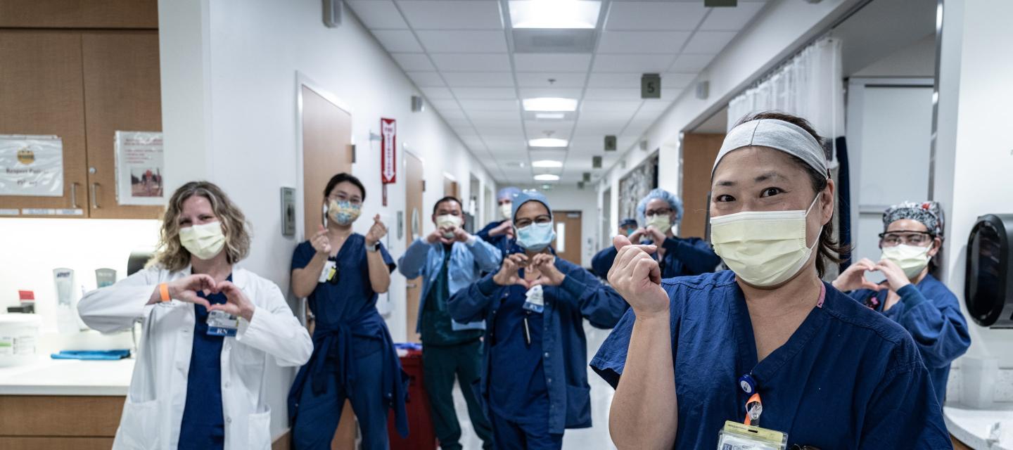 City of Hope doctor and nurses symbolling hearts with their hands in the facility hallway