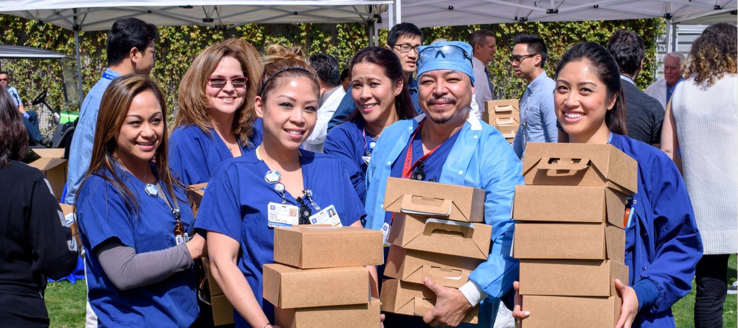 Nurses holding boxes of food at the event