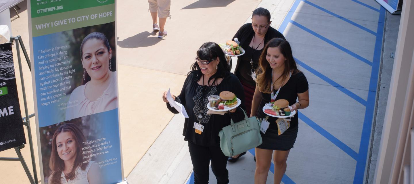 Three participants at the event, holding plates of food