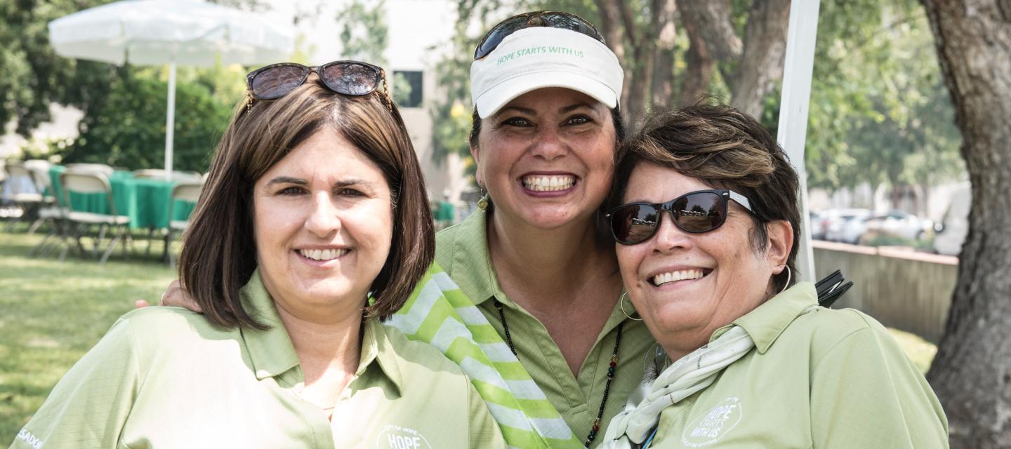 Three ladies smiling at Hope Starts with Me employee giving event
