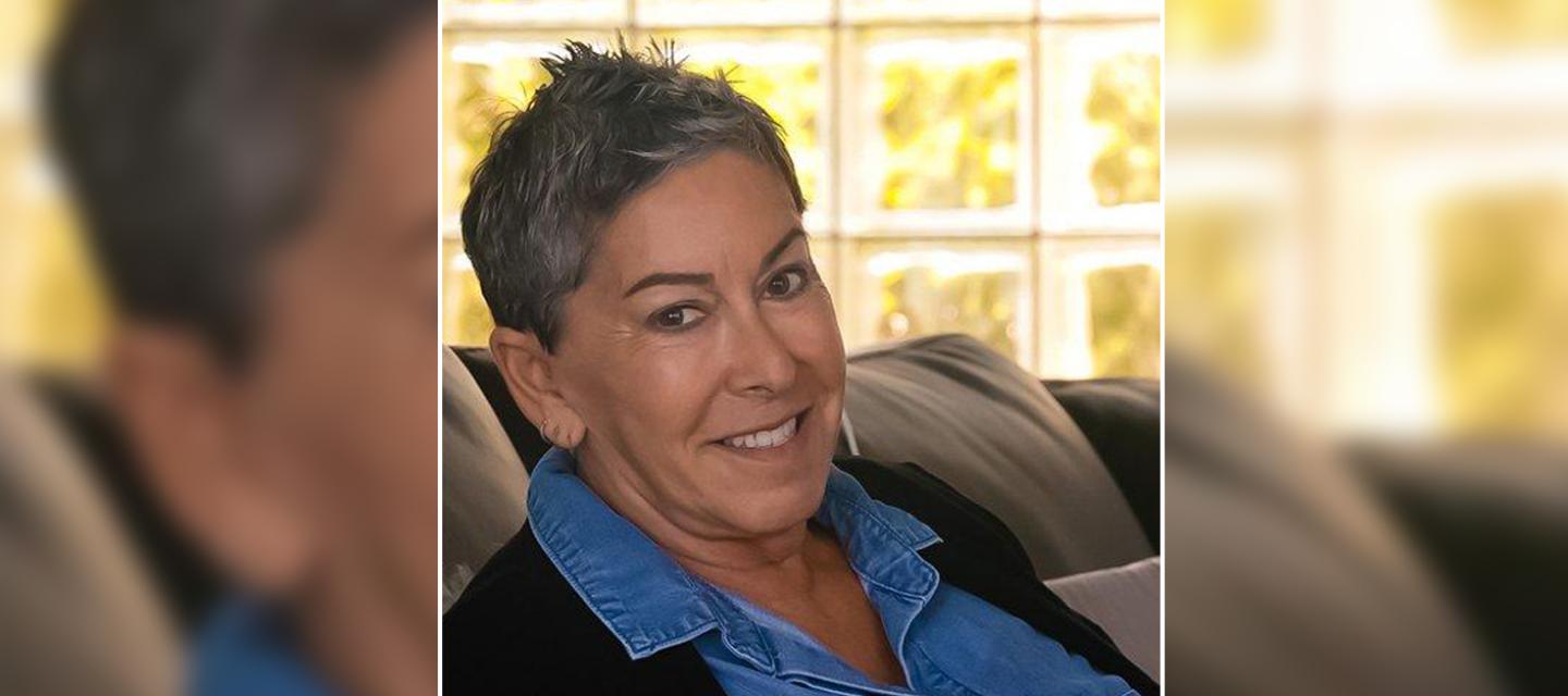 Lung Cancer Survivor Abby Kanarek sitting on a couch, smiling