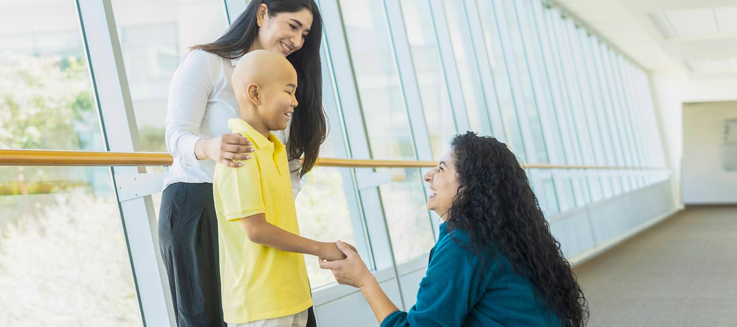 A pediatric cancer patient with their parent and care team member at City of Hope