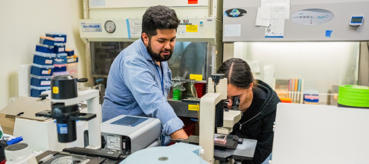 City of Hope graduate school student trains VERT student how to use a microscope.