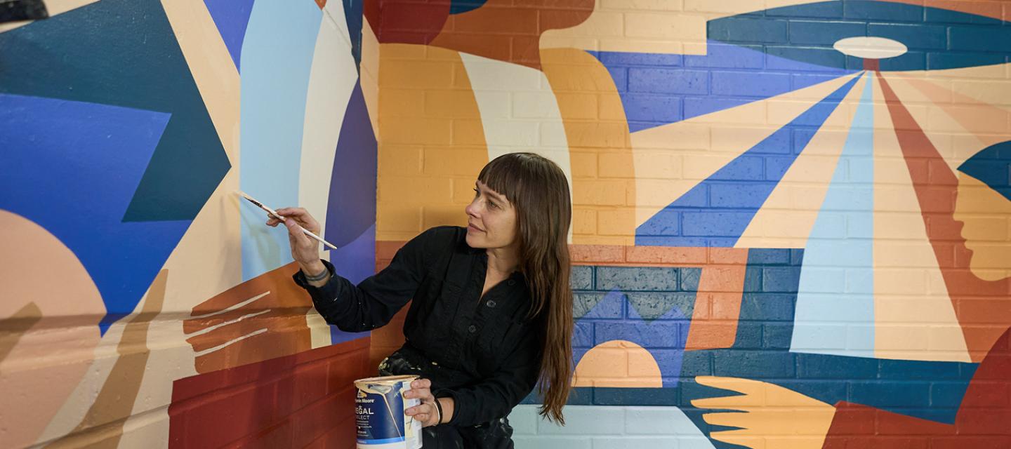 Artist Sarah Buckley painting mural at Newport Beach Lido