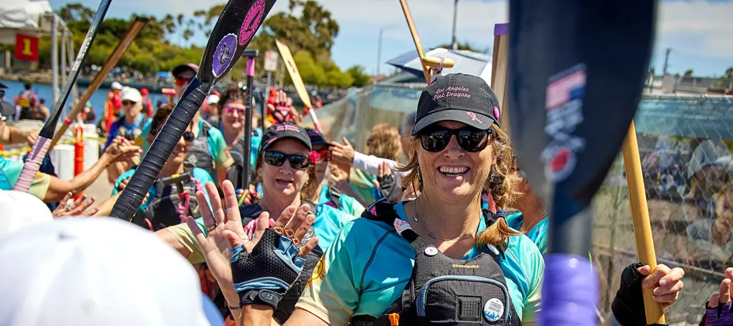 Los Angeles Pink Dragons team members with paddles at a dragon boat event