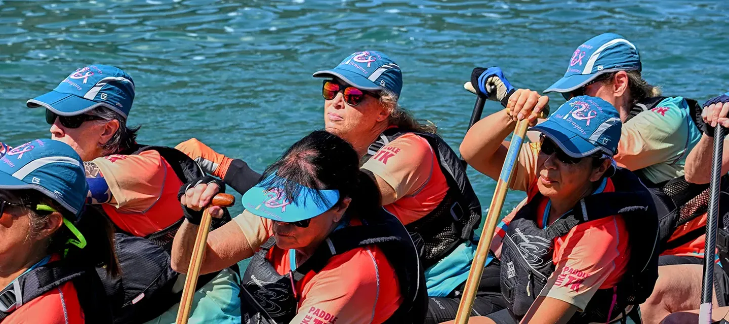 Pink Dragons paddlers rowing together during a dragon boat race