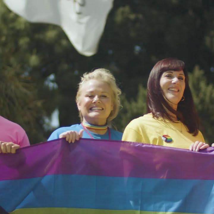 Four people holding pride flag