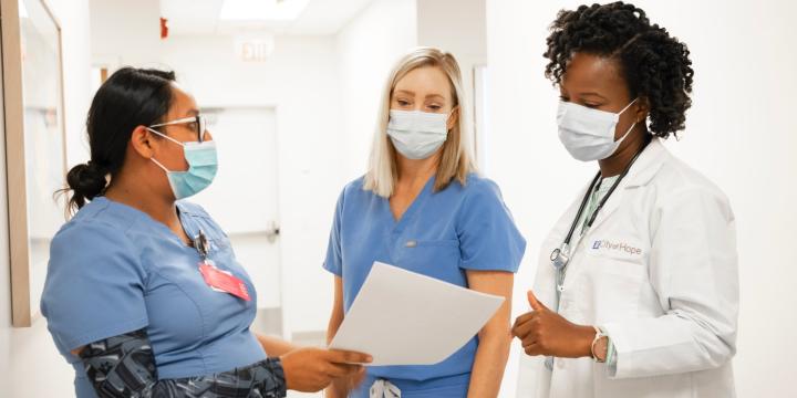 A doctor talking with two nurses about a report