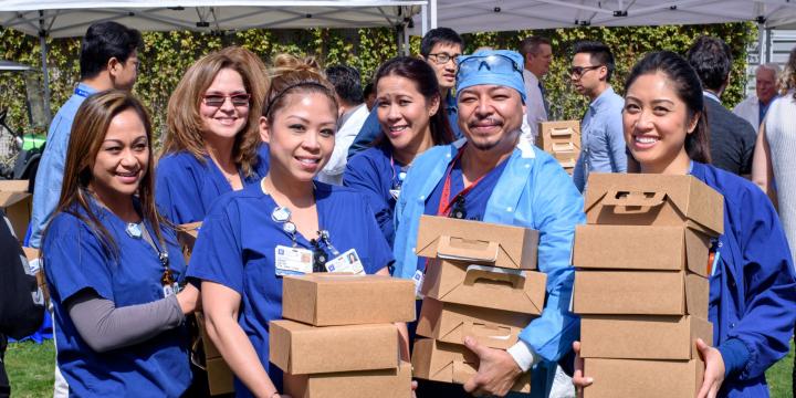 Nurses holding boxes of food at the event