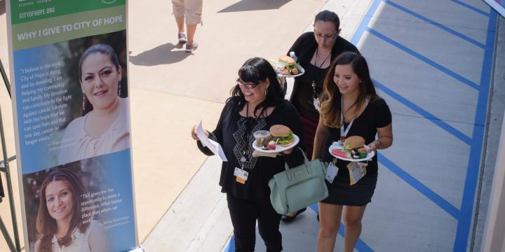 Three participants at the event, holding plates of food