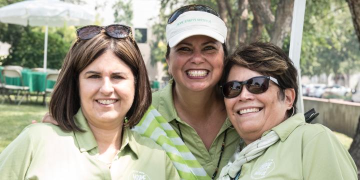 Three ladies smiling at Hope Starts with Me employee giving event