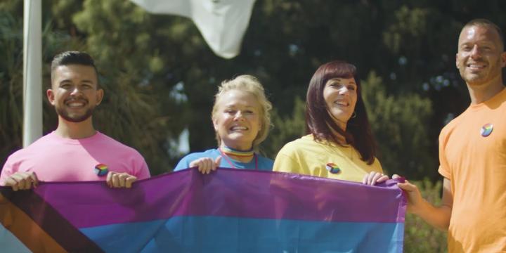 Four people holding pride flag