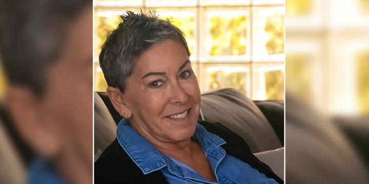 Lung Cancer Survivor Abby Kanarek sitting on a couch, smiling