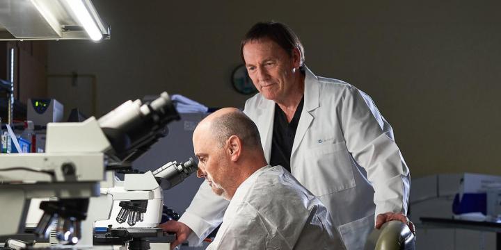 Phoenix researcher looking through microscope