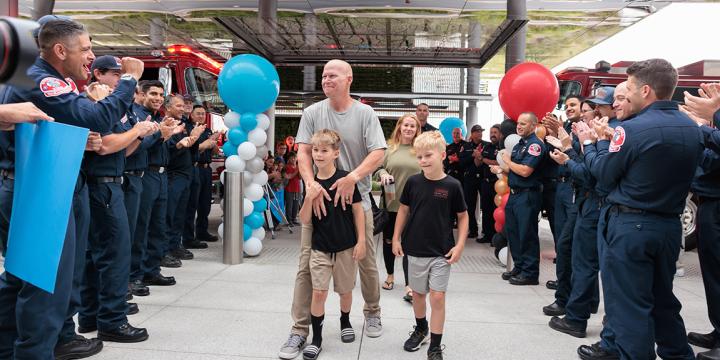 Brandon Willson, his sons Gavin and Luke, and wife Amber walk through dozens of firefighters as they show their support for the battalion chief