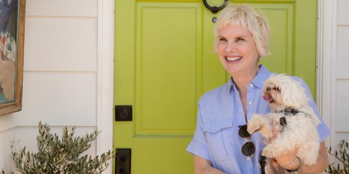 Donna McNutt holding her dog in front of a door