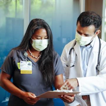 A doctor reviewing paperwork with a nurse