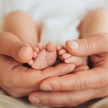 Hands around a child's feet