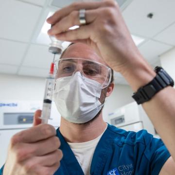 A nurse prepares a syringe