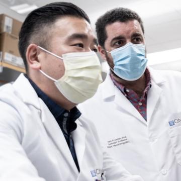 Two masked doctors working together