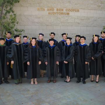 Irell & Manella Graduate School grads in front of the Rita and Ben Cooper Auditorium building