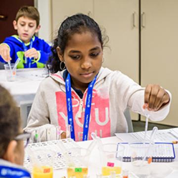 young girl using lab utensils