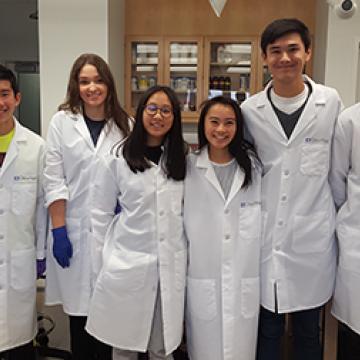 group of high school students in lab coats