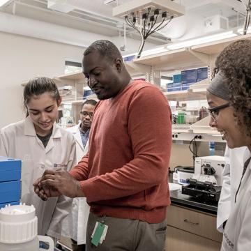 Instructor and three students in a lab