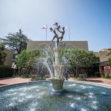 A photo of a fountain in front of the City of Hope building.
