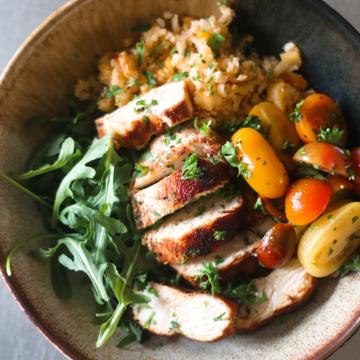Bowl with arugula, couscous, tomatoes and chicken 
