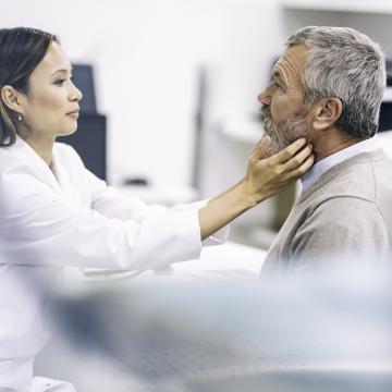 Doctor examining patient's neck