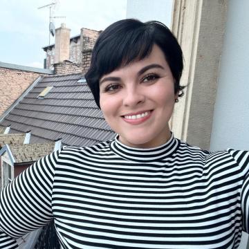 Shirley Munoz smiling by a window