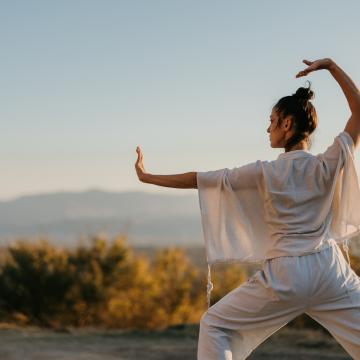 Woman dressed in white doing tai chi