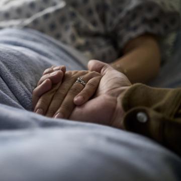A City of Hope patient holds hands with a loved one