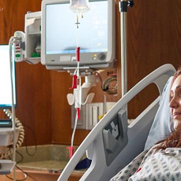 doctor speaking with a woman in a hospital bed and a man sitting beside her