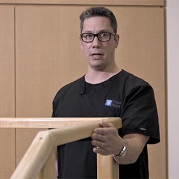 A physical therapist demonstrates shoulder stretches.
